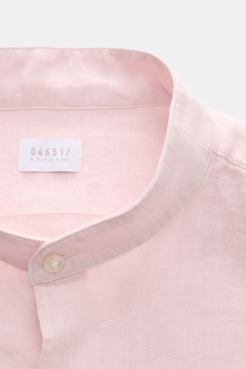 Close-up front view of the 04651/ A trip in a bag Linen shirt 'Linen Guru' grandad collar rose in soft pink linen fabric with button and label. Summer for your skin: The airy casual shirt 'Linen Guru' by 04651/ A TRIP IN A BAG is made of pure linen fabric