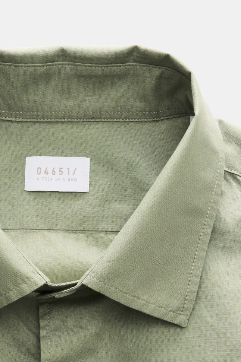 Close-up front view of the slim collar on the 04651/ A trip in a bag Casual shirt 'Cloudy Shirt' slim collar sage in light green cotton.

Lightweight and comfortable for hot days: The casual shirt 'Cloudy Shirt' by 04651/ 