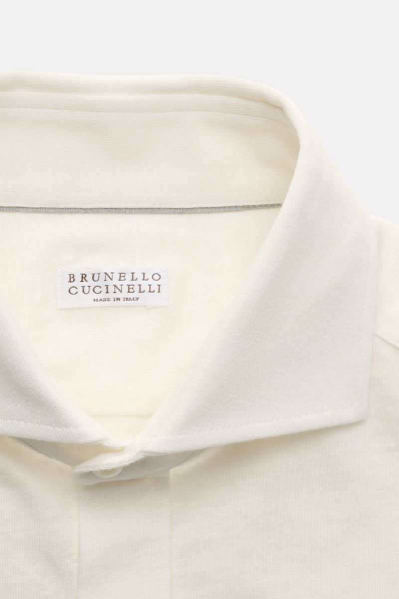 Close-up front view of Brunello Cucinelli Jersey-Hemd Haifisch-Kragen creme, showcasing the shark collar and soft linen-cotton fabric.

Zeitlose Raffinesse: Das BRUNELLO CUCINELLI Jersey-Hemd vereint außergewöhnlichen Tragekomfort mit eleganter Zurückh
