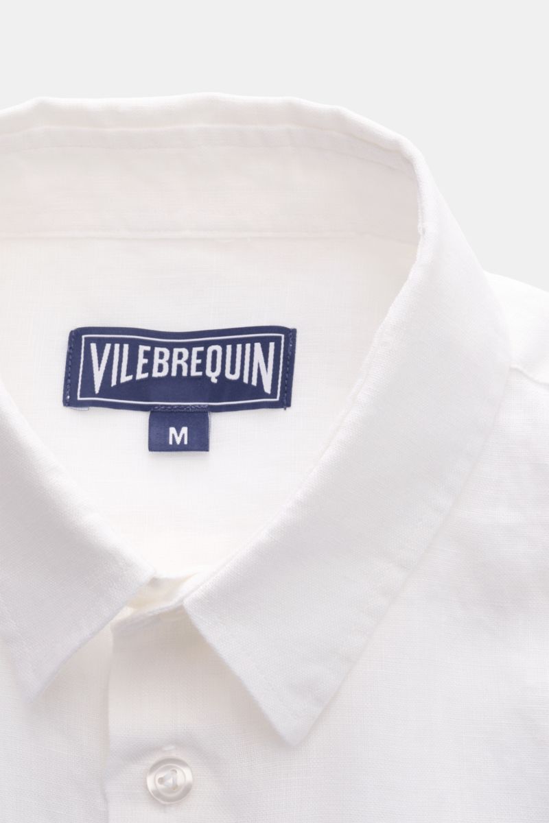 Close-up front view of Vilebrequin Leinenhemd schmaler Kragen weiß linen shirt collar and label, showing leichte Qualität, weicher Griff, Regular Fit, schmaler Kragen, französische Knopfleiste, klassische Sportmanschette, aufgesetzte Brusttasche, gerundet