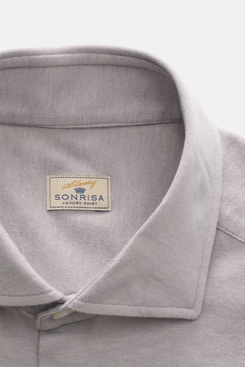 Close-up front view of the Sonrisa Jersey shirt shark collar grey showcasing soft cotton-lyocell fabric and detailed stitching.

Comfort meets style: This jersey model in a soft cotton-lyocell blend by SONRISA adds a touch of elegance to any smart-casu