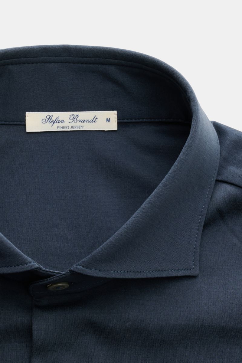 Stefan Brandt Jersey shirt 'Otis' shark collar dark blue shown in close-up from above, highlighting soft Pima cotton fabric, slim fit, French button placket with mother-of-pearl buttons, classic barrel cuffs, and rounded hem. Flexible, soft jersey made of