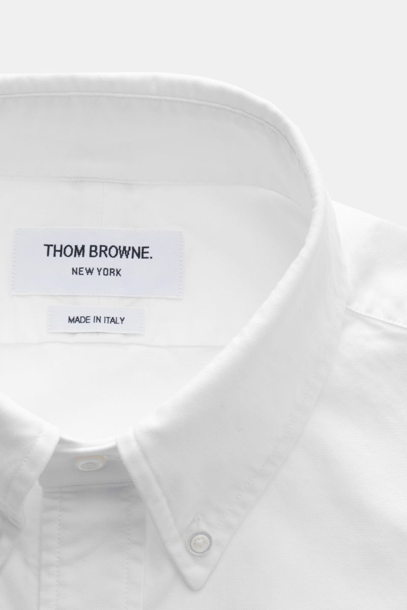 Nahaufnahme des weißen Thom Browne Kurzarmhemds Button-Down-Kragen mit Oxford-Baumwolle, weichem Griff und aufgesetzter Knopfleiste.