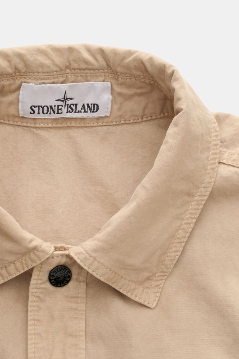 Stone Island Kurzarmhemd 'Brushed Canvas' Kent-Kragen beige, weiche Bio-Baumwolle, Regular Fit, verdeckte Knopfleiste, Brusttasche, Kompass-Badge, Nahaufnahme von oben.