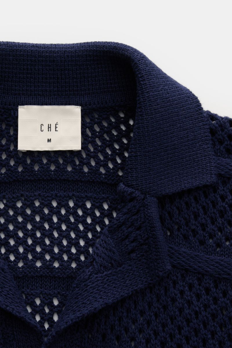 Nahaufnahme von Ché Kurzarm-Strickhemd 'Desiderio' Kubanischer Kragen navy mit grobem, luftigen Strickmuster und Perlmutt-Knöpfen, von oben fotografiert.