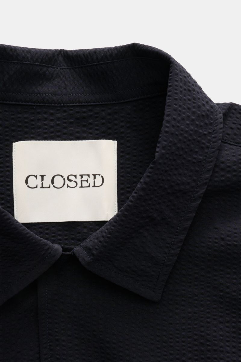 Nahaufnahme des Closed Kurzarmhemd Kubanischer Kragen dark navy, Frontansicht, strukturierter Seersucker aus Microfaser, flexibler Kragen.
