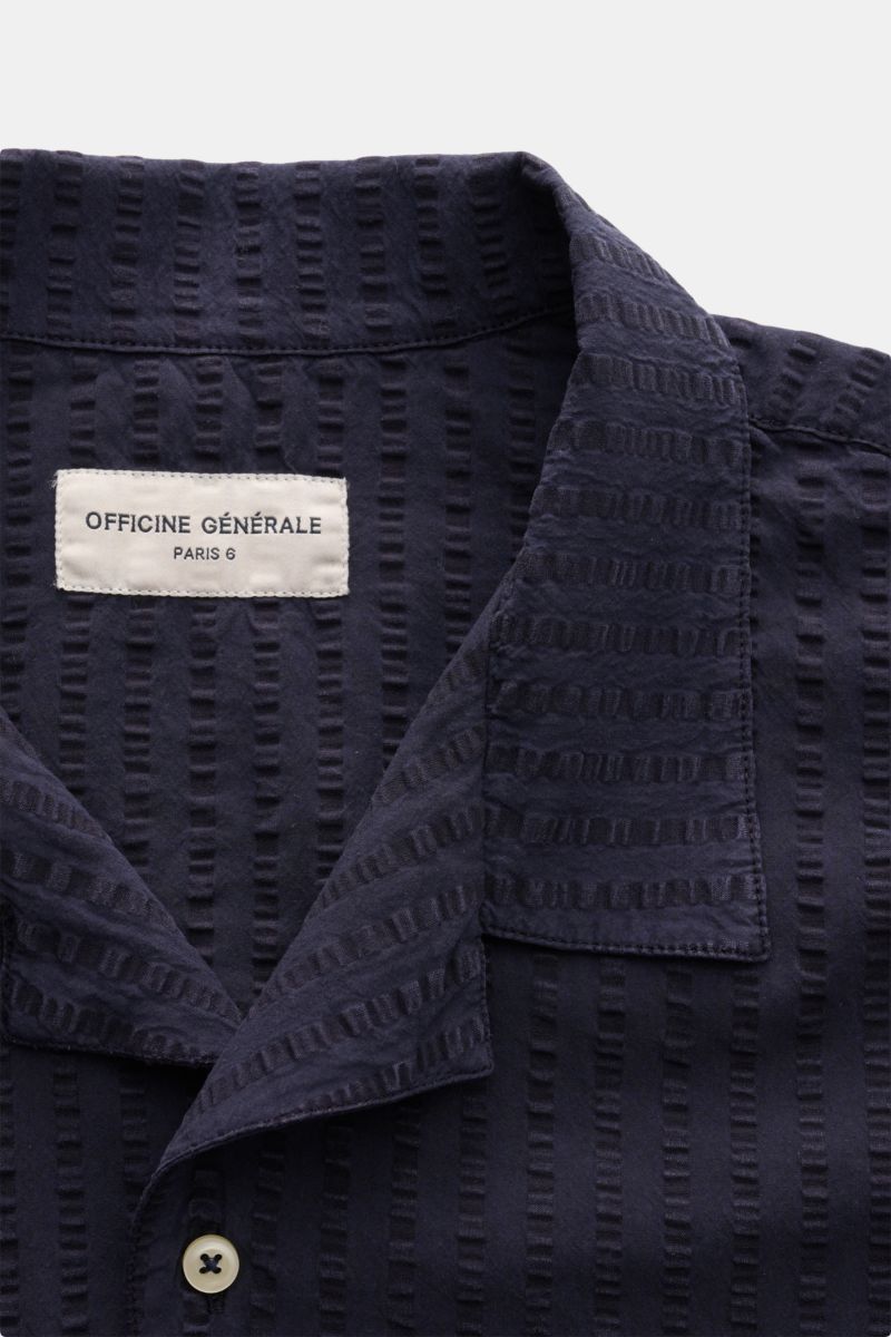 Close-up front view of Officine Générale Short sleeve shirt 'Eren' Cuban collar navy, showing lightweight textured seersucker fabric, French button placket, and label. Get a casual look for warm days: This short sleeve shirt by OFFICINE GÉNÉRALE has a lig