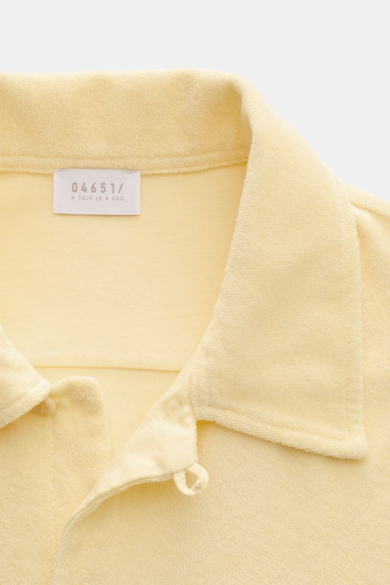 Close-up front view of the 04651/ A trip in a bag Frottee-Kurzarmhemd 'Terry Cuba' pastellgelb short-sleeve shirt collar in soft pastel yellow cotton terry fabric with a variable Cuban collar, French button placket, and small side seam label. Urlaubsgefüh