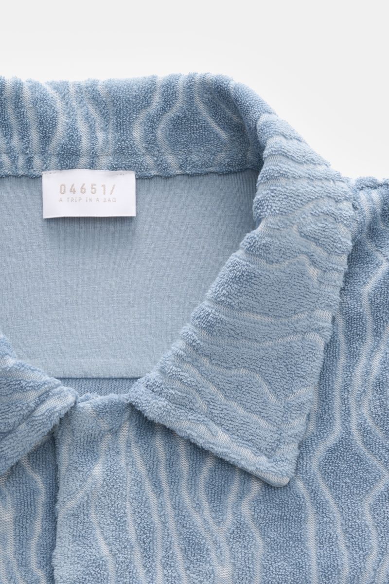 Close-up front view of the 04651/ A trip in a bag Terry short-sleeved shirt 'Terry Superkilen' Cuban collar smoky blue, made from soft terry fabric with an all-over pattern inspired by Copenhagen's 'Superkilen' park. Holiday feel you can wear: Blend of co