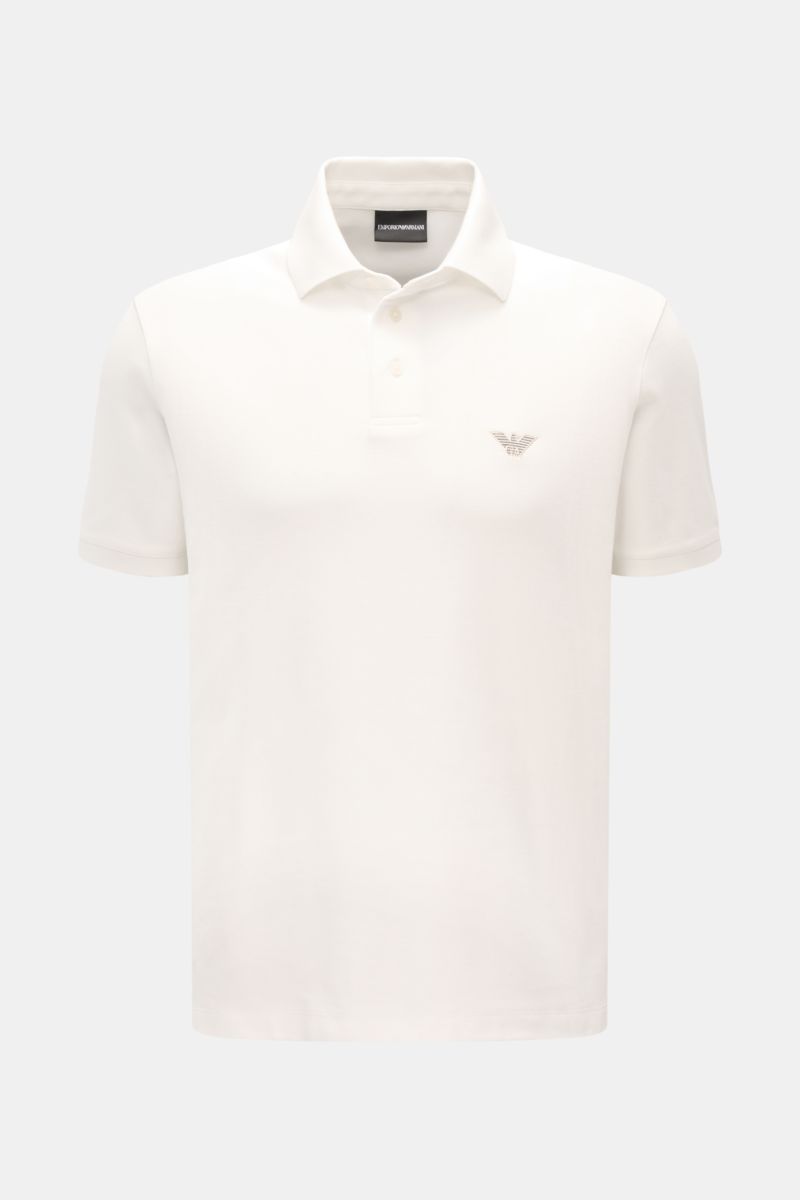 Emporio Armani Poloshirt offwhite shown from the front, featuring a classic polo collar, label stitching on chest, short sleeves, side hem slits, made from pure cotton piqué jersey with a slightly textured feel, regular fit. Vielseitiger Klassiker für spo
