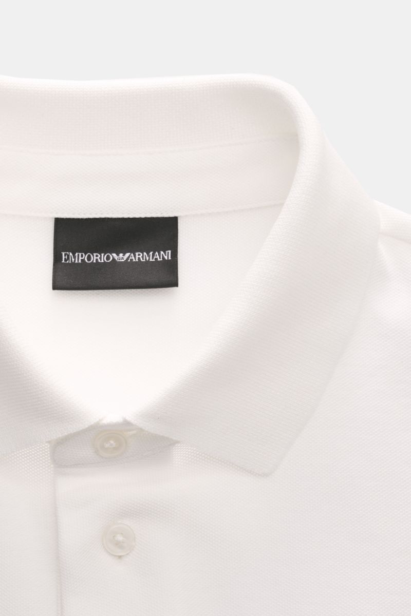 Close-up front view of Emporio Armani Poloshirt offwhite showing classic polo collar, buttons, and label stitching, made of pure cotton piqué jersey with regular fit and side slits. Vielseitiger Klassiker für sportive Looks: Das Poloshirt von EMPORIO ARMA