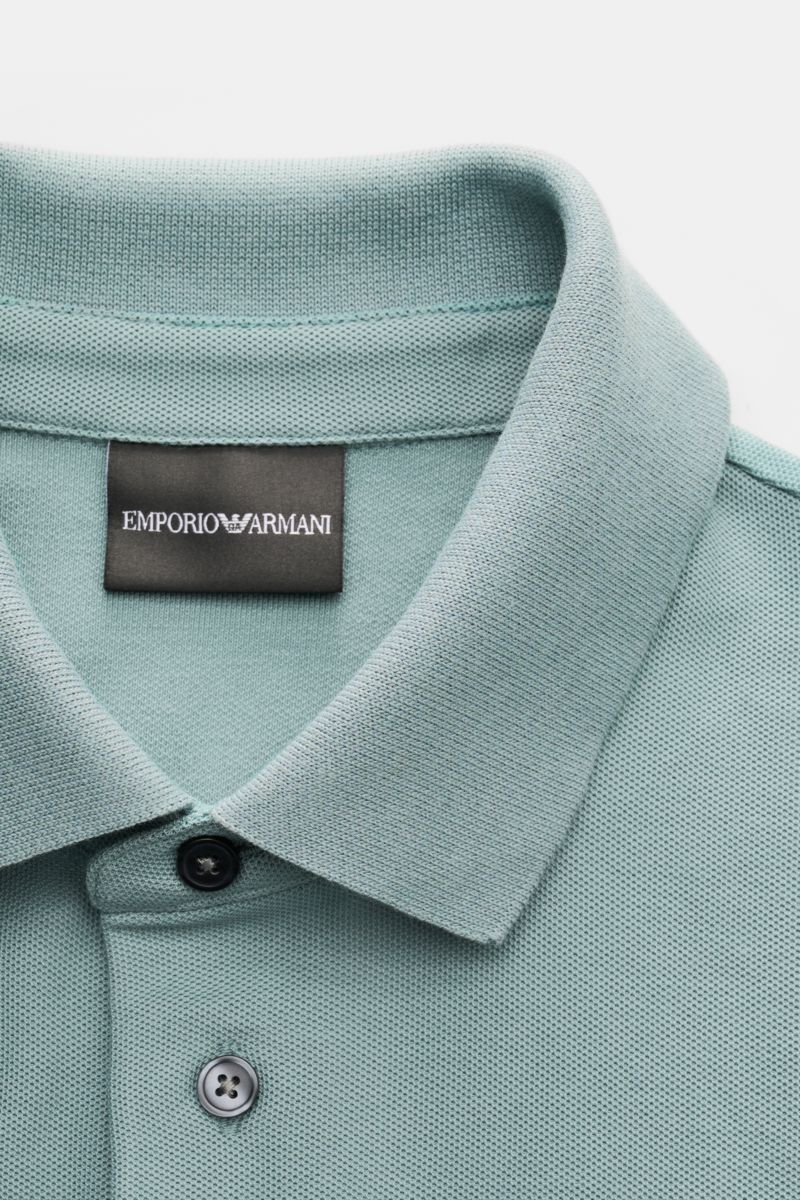 Close-up front view of the Emporio Armani Polo shirt sage, showing the classic collar, two buttons, and label stitching on the chest. A versatile classic for sporty looks: This polo shirt by EMPORIO ARMANI has a timeless, casual design. Piqué jersey made 