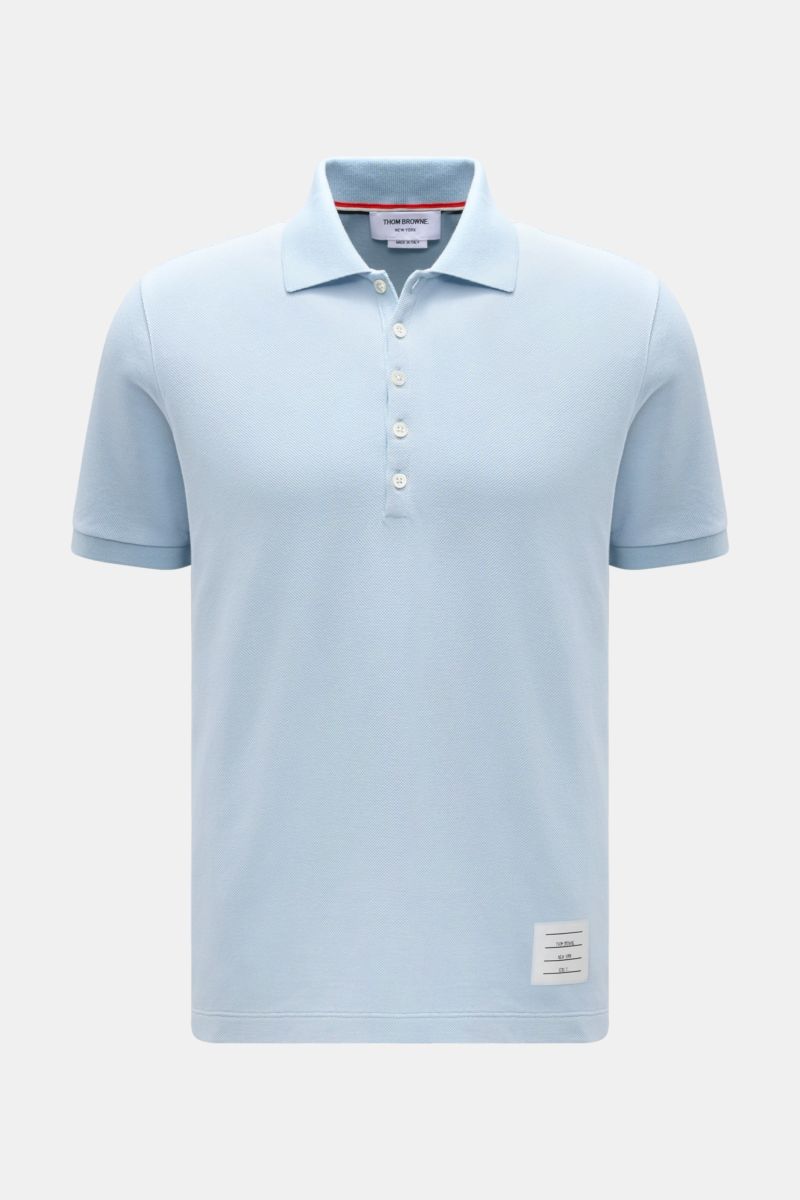Front view of Thom Browne Poloshirt hellblau in light blue, slim fit with classic collar, five-button placket, ribbed sleeve cuffs, elastic side ribs, pure cotton, textured fabric, and signature stripe logo.