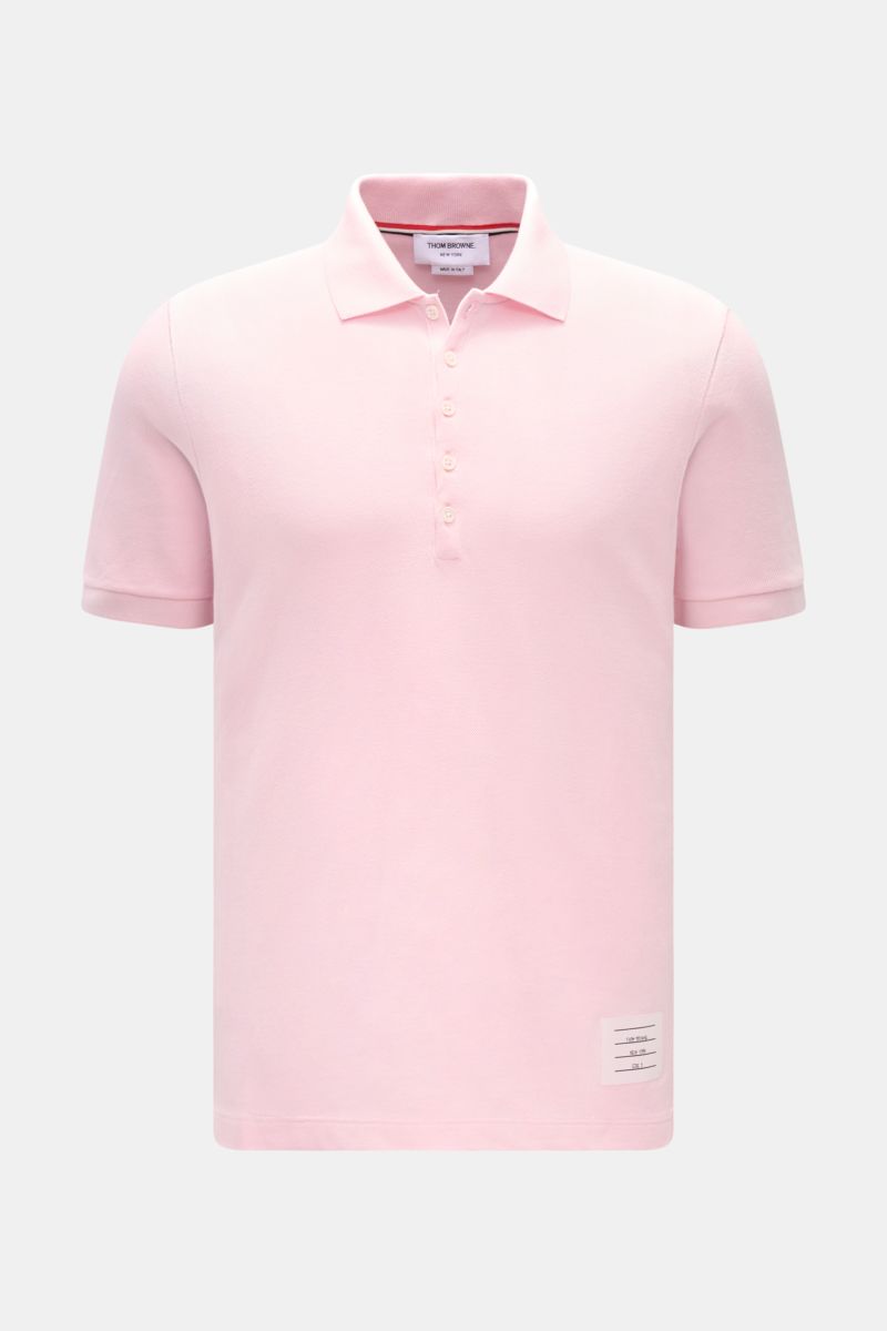Front view of Thom Browne Poloshirt rosé in slim fit, made of pure cotton with a classic collar, five-button placket, ribbed cuffs, elastic side inserts, and signature stripe logo, showcasing a modern essential with luxurious comfort.