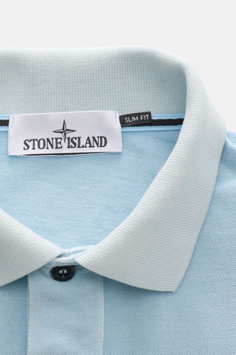 Close-up front view of Stone Island Poloshirt hellblau showing light blue cotton piqué fabric, typical polo collar, smooth two-button placket, and STONE ISLAND label with slim fit tag.  
Description: Der Klassiker von STONE ISLAND: Das sportive Poloshirt 
