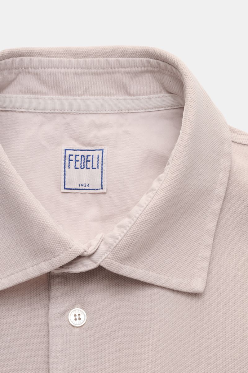 Fedeli Poloshirt 'North' beige close-up from above showing clean collar, mother-of-pearl button, and soft cotton piqué fabric.  
Quiet Luxury: Das cleane Poloshirt 'North' aus hochwertigem Baumwoll-Piqué von FEDELI kommt ganz ohne Logos aus und wurde i