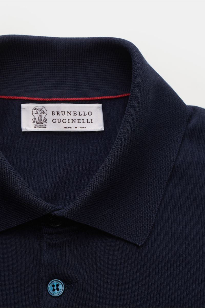 Close-up front view of Brunello Cucinelli Short sleeve knit polo shirt navy showing collar, label, and top button in fine knit fabric.

This timeless short-sleeved polo shirt from BRUNELLO CUCINELLI features a lightweight, fine knit fabric made from su