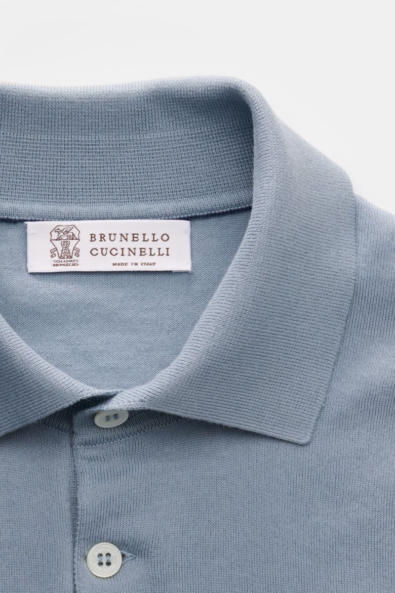Close-up image from above showing the collar and buttons of the Brunello Cucinelli Kurzarm-Strickpolo rauchblau, a slim fit polo made of soft, fine knit pure cotton with classic collar, three-button placket, narrow contrasting edges, and flexible ribbed c