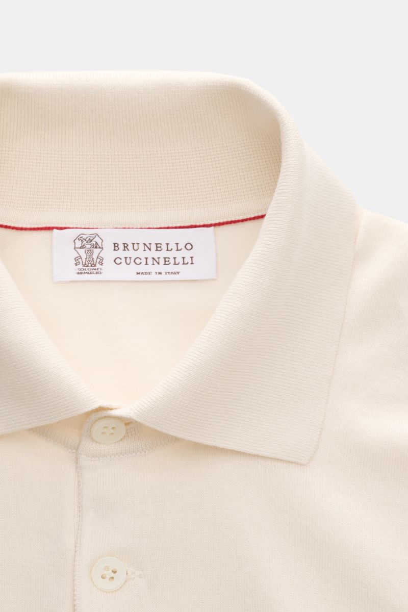 Close-up front view of the Brunello Cucinelli Kurzarm-Strickpolo creme, showcasing its classic polo collar, three-button placket, and fine cream-colored knit.

Luxuriöse Alltags-Looks profitieren von der leichten Strickqualität dieses zeitlosen Kurzarm