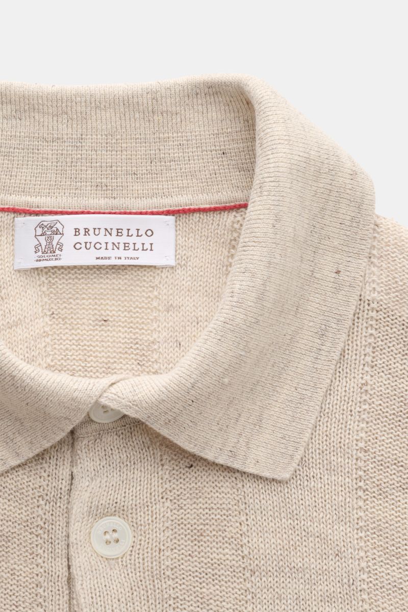 Close-up front view of the Brunello Cucinelli Kurzarm-Strickpolo sand meliert showing the collar, buttons, and label. Elegantes Highlight in der Frühlings- und Sommersaison: Das luxuriöse Strickpolo von BRUNELLO CUCINELLI überzeugt mit außergewöhnliche