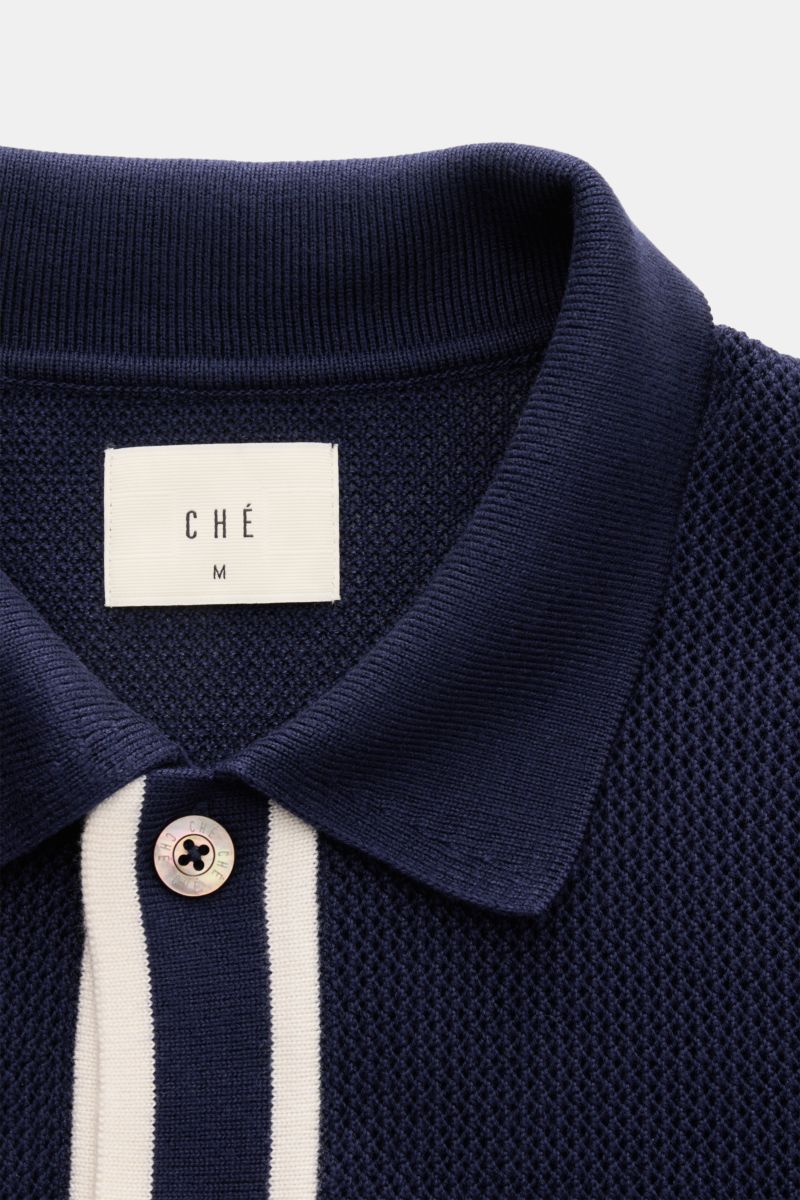 Close-up front view of the Ché Kurzarm-Strickhemd 'Jorge' navy, a knitted short-sleeve shirt with a navy collar, fine airy knit, wide white contrast stripes, mother-of-pearl buttons, and a straight hem. Ob offen über einem T-Shirt oder geschlossen getr