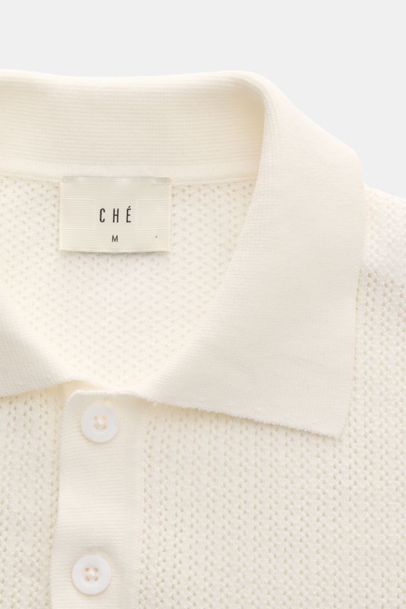 Close-up front view of Ché Kurzarm-Strickpolo 'Quinn' weiß/hellbraun with knitted collar, three-button placket, and airy knit pattern. Genießen Sie die Leichtigkeit des Sommers mit dem luftigen Kurzarm-Strickpolo 'Quinn' von CHÉ. Kontrastierende, gestreif