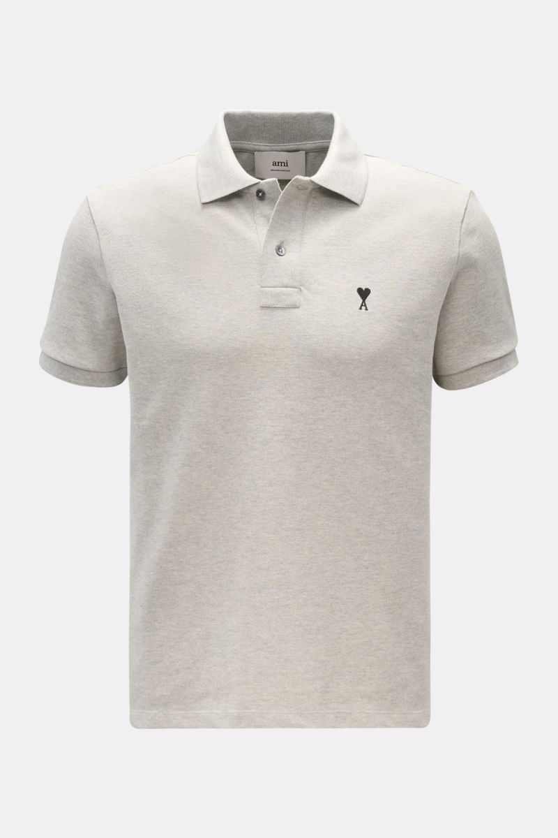 A front view of the Ami Paris Poloshirt grau meliert, a classic unisex piqué polo shirt in light grey made from organic cotton with 'A' logo stitching on the chest, featuring a typical polo collar, two-button placket, elastic sleeve cuffs, fine piqué text