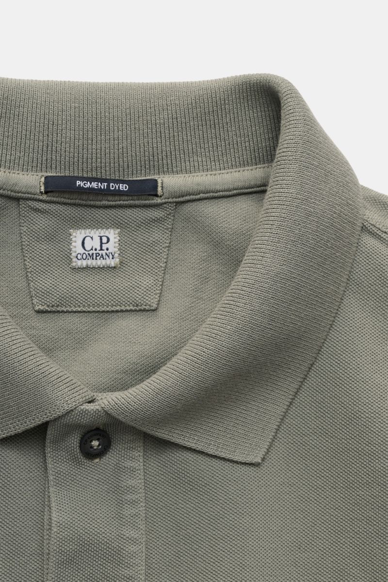 C.P. Company Poloshirt grau, Nahaufnahme von oben, Baumwoll-Piqué, Pigment-Dye, klassischer Polokragen, Zwei-Knopf-Leiste, kleines Weblabel auf der Brust.