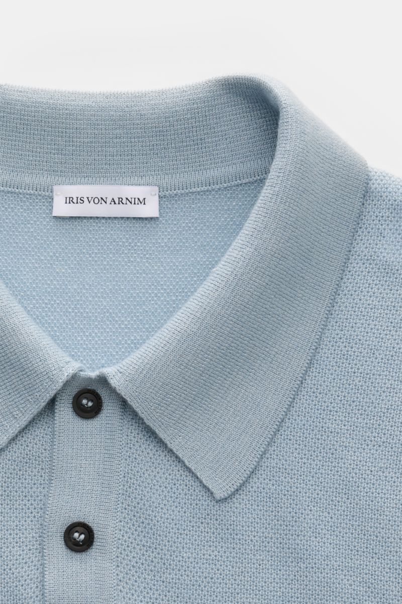 Close-up front view of the light blue Iris von Arnim Kurzarm-Strickpolo 'Pavion' showing its classic polo collar and two-button placket. Luxuriöser Allrounder: Das edle Strickpolo von IRIS VON ARNIM verbindet Exklusivität mit unvergleichlichem Komfort und