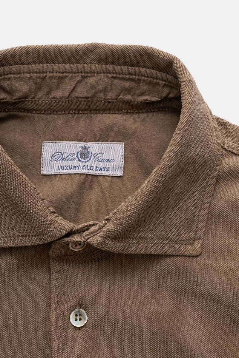 Nahaufnahme des Della Ciana Poloshirts braun von oben, zeigt Baumwoll-Piqué, Polokragen, Drei-Knopf-Leiste, feine Struktur.