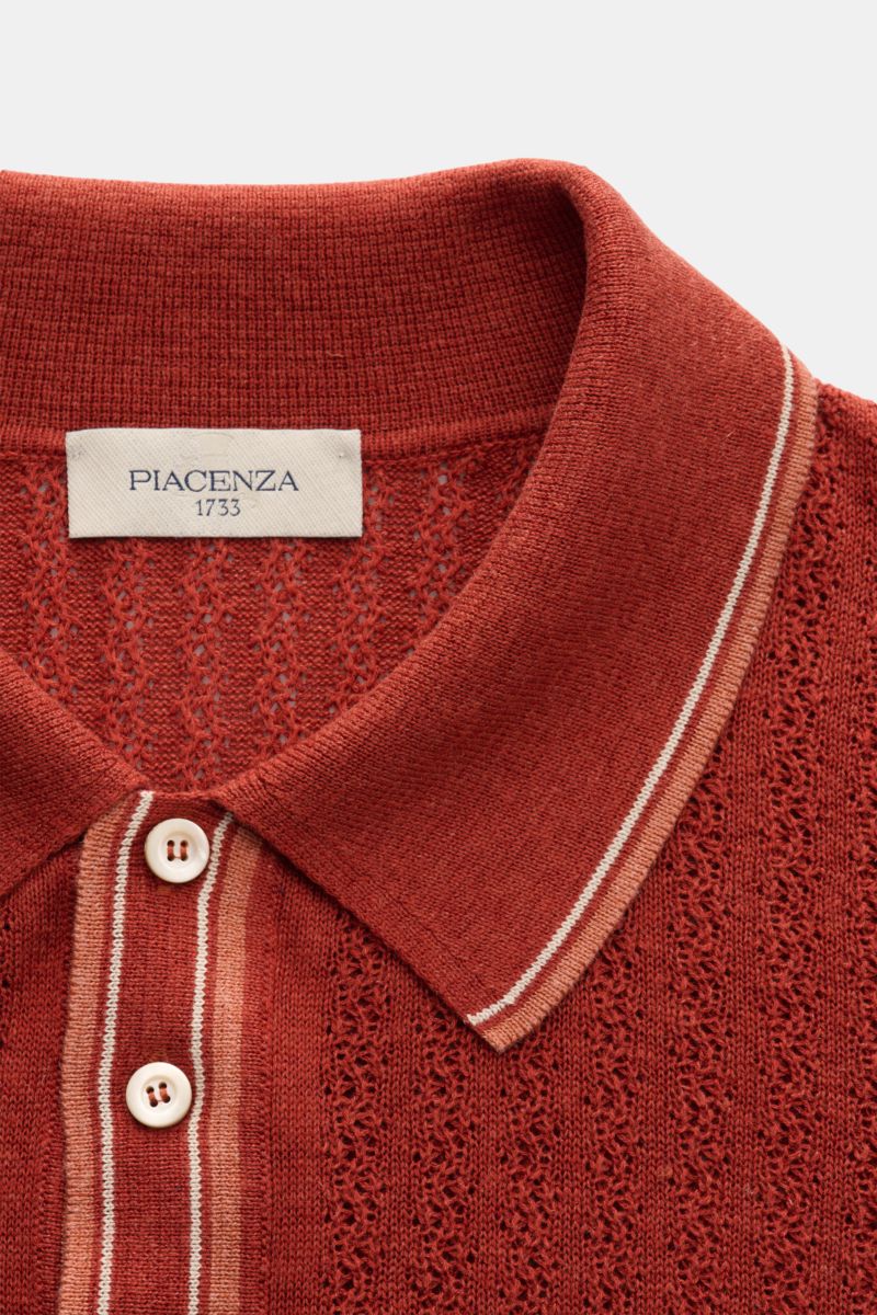 Close-up front view of the Piacenza 1733 Kurzarm-Strickpolo rostbraun, a short-sleeve knit polo with a rust brown color, featuring a classic polo collar with striped trim and two white buttons. The shirt showcases a mid-fine striped textured knit design m