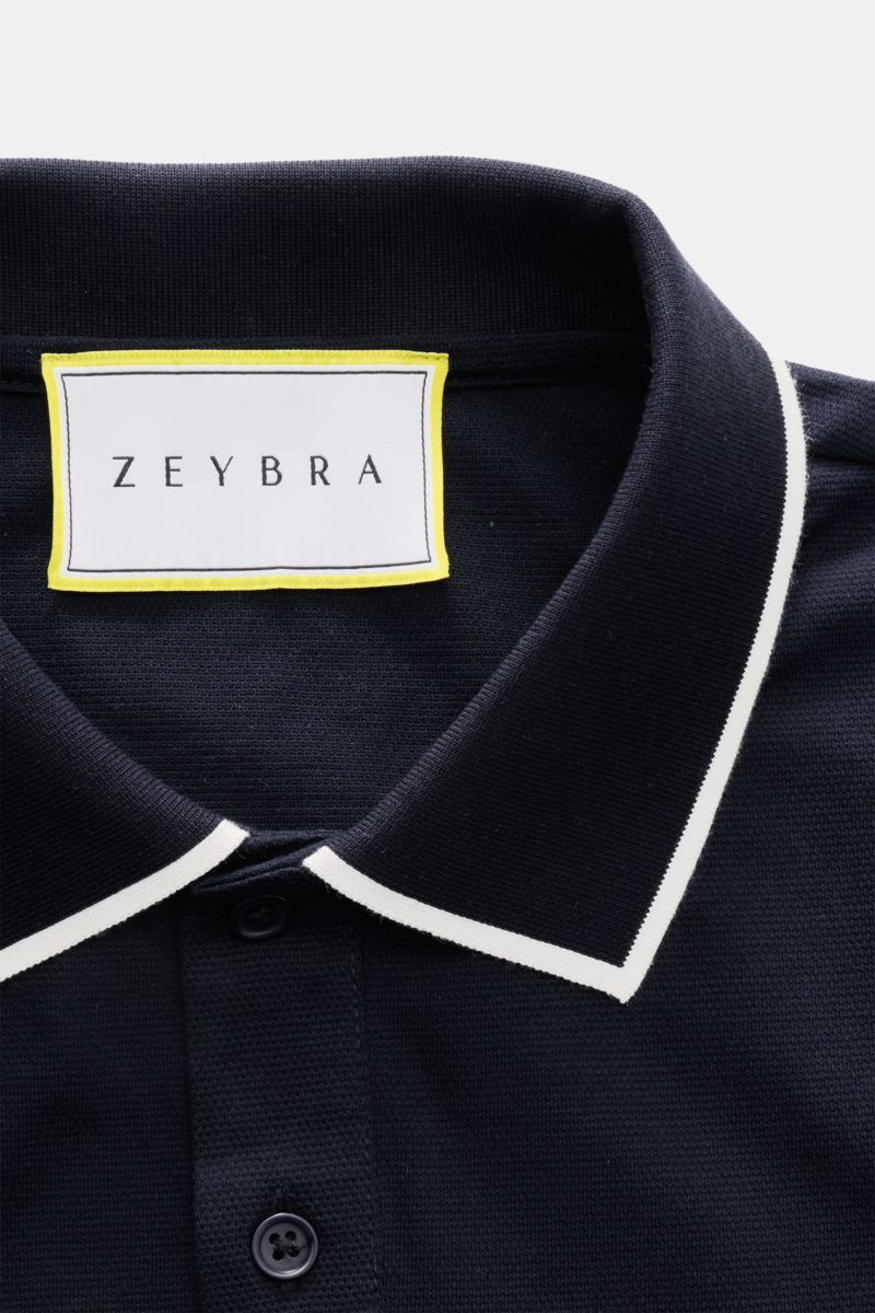 Close-up, top-down view of the Zeybra Portofino 1962 Poloshirt navy showing its ribbed collar with white contrast edges and two-button placket, featuring the ZEYBRA label inside.

Entspannt in Office und Freizeit: Das Poloshirt von ZEYBRA PORTOFINO 196
