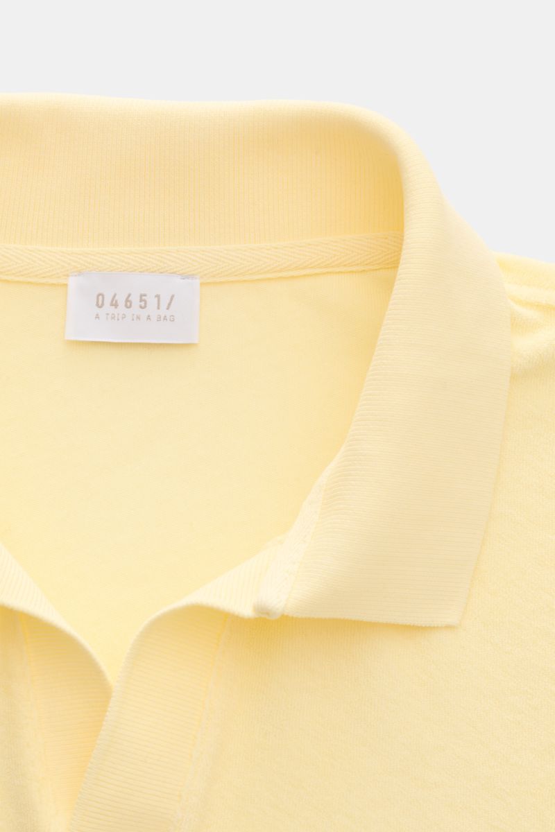 Close-up front view of 04651/ A trip in a bag Terry polo shirt 'Terry Johnny' pastel yellow with signature collar and open collar strip.

Holiday feel you can wear: This short sleeve polo shirt in comfortable cotton terry by 04651/ A TRIP IN A BAG is a