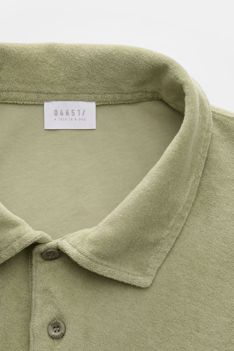 04651/ A trip in a bag Frottee-Poloshirt 'Terry Polo' salbei, Nahaufnahme von Polokragen, Knopf und weichem Baumwollstoff aus Frottee.