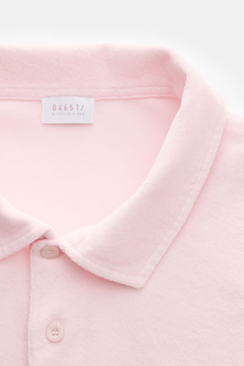 Nahaufnahme, schräge Vogelperspektive auf das roséfarbene 04651/ A trip in a bag Frottee-Poloshirt 'Terry Polo' mit Polokragen, Knopfleiste und weichem Baumwoll-Frottee.