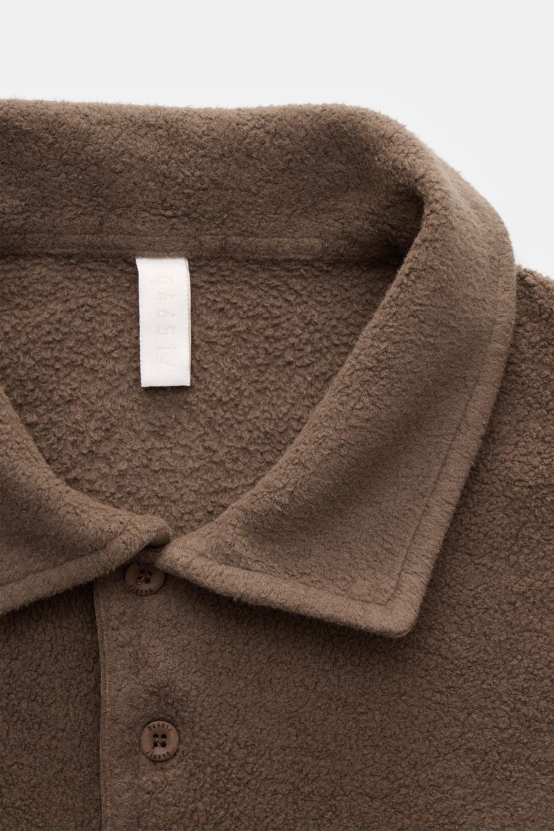 Braunes 04651/ A trip in a bag Fleece Langarm-Poloshirt, Detailaufnahme von oben, Fleece aus reiner Baumwolle, softer Griff, garment dyed, Regular Fit, typischer Polokragen, Drei-Knopf-Leiste, kleines Weblabel in der Seitennaht, kurze Saumschlitze.