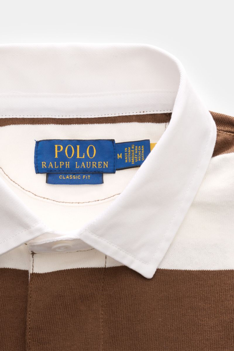 Close-up front view of the collar area of the Polo Ralph Lauren Jersey Longsleeve-Poloshirt weiß/braun gestreift, showing its classic white polo collar and brown and white striped jersey fabric, highlighting the blue label with yellow text. Legerer Kla