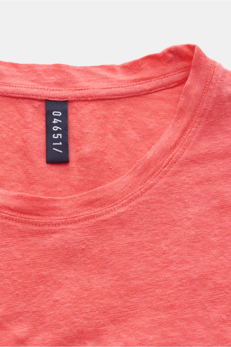 Nahaufnahme des Rundhalsausschnitts vom 04651/ A trip in a bag Leinen Rundhals-T-Shirt koralle aus elastischem, garment dyed Leinen mit materialtypischer Struktur.