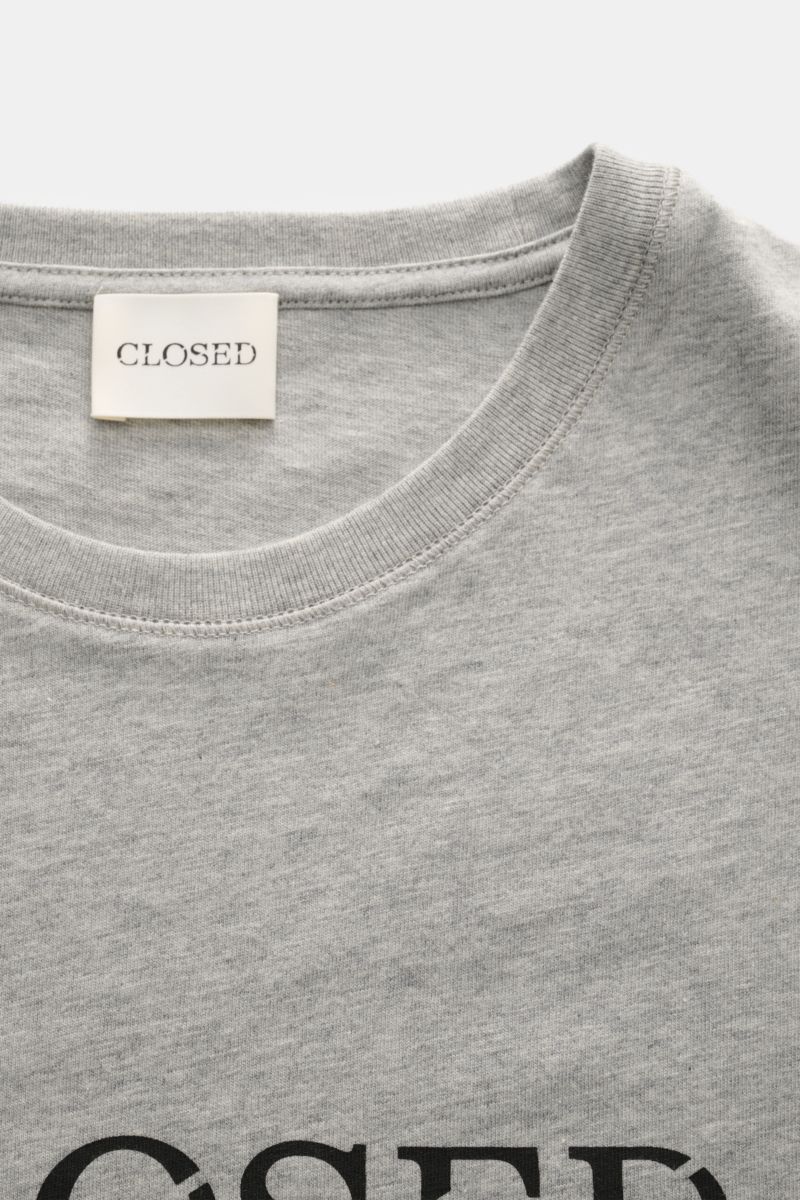 Closed Rundhals-T-Shirt grau meliert shown in a close-up front view of the neckline and upper chest, featuring pure cotton, soft touch, regular fit, round neckline, bold logo print, and short side slits, exemplifying urban streetstyle and easy pairing wit