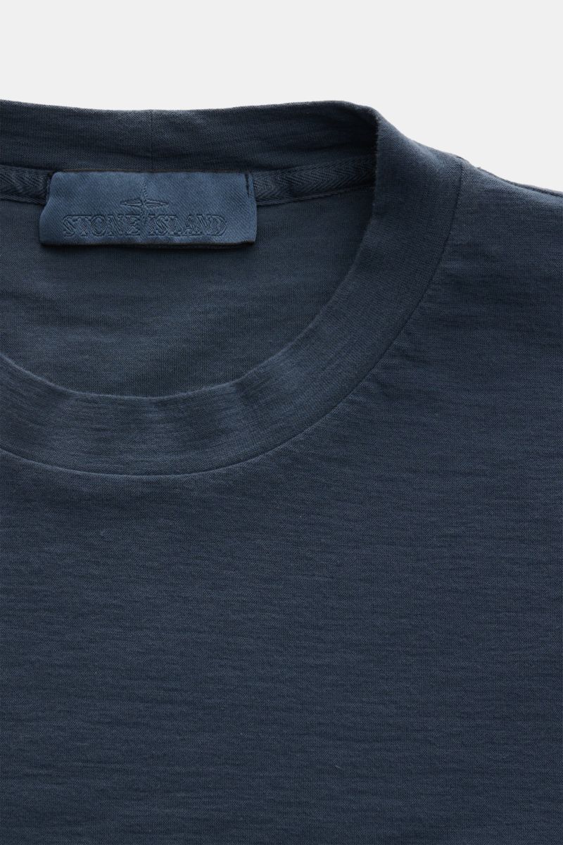 Nahaufnahme des Stone Island Rundhals-T-Shirts 'Ghost Piece' graublau, Slim Fit aus elastischem Baumwolljersey mit tonalem Weblabel frontal fotografiert.