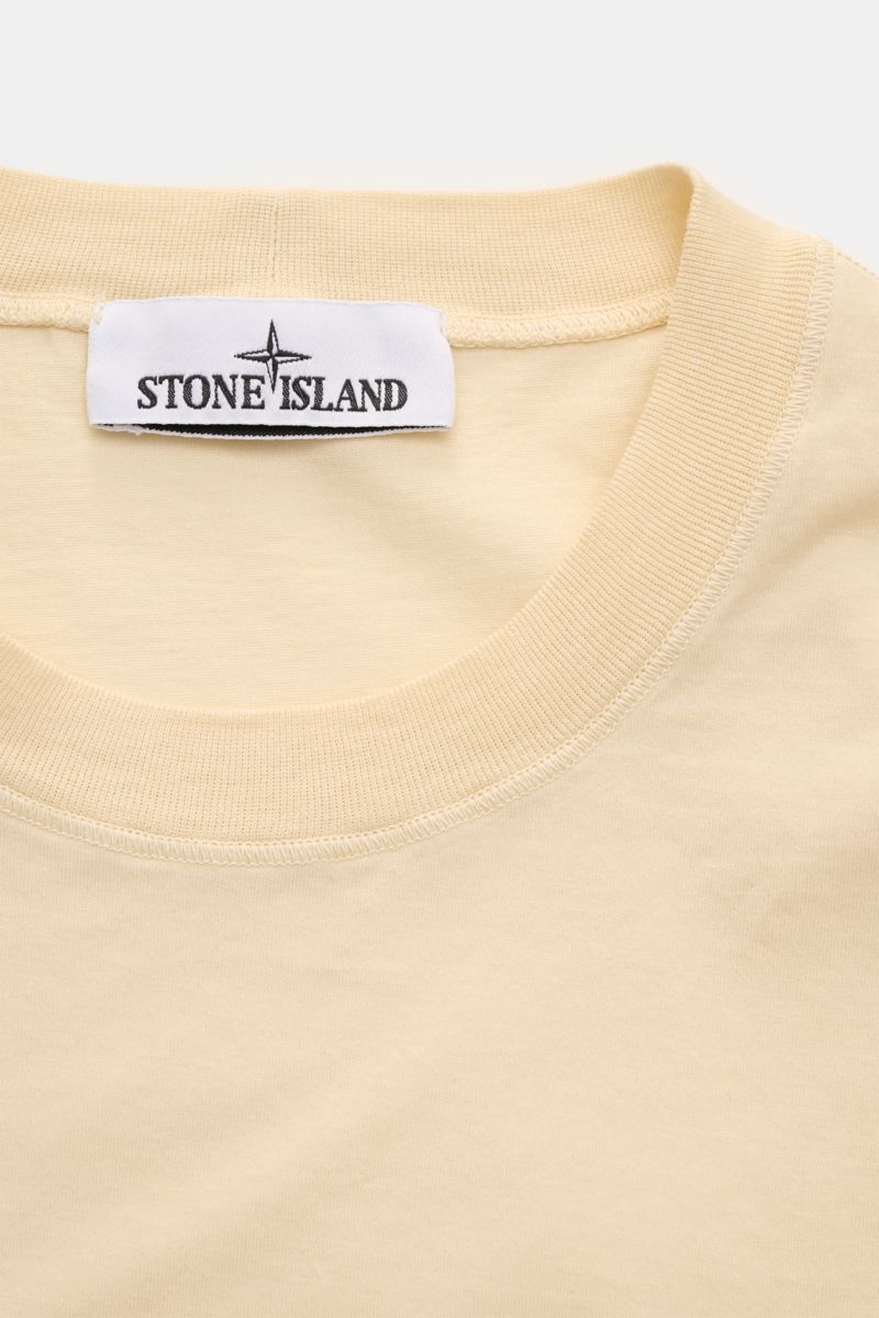 Stone Island Crew neck T-shirt 'Stellina' pastel yellow shown from a close-up top front perspective, highlighting the ribbed collar and brand label.

Minimalist expression and precise workmanship: The T-shirt 'Stellina' from the Capsule Collection by S