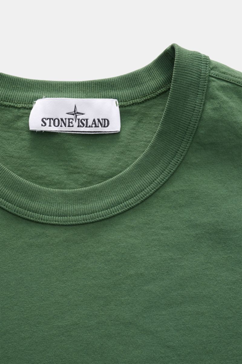 Stone Island Rundhals-T-Shirt 'Marina' grün shown in close-up from above, highlighting the ribbed round neckline and label.

Legeres Urlaubs-Essential: Das T-Shirt aus der STONE ISLAND 'Marina' Capsule Collection steht für lässige Looks mit maritimer N