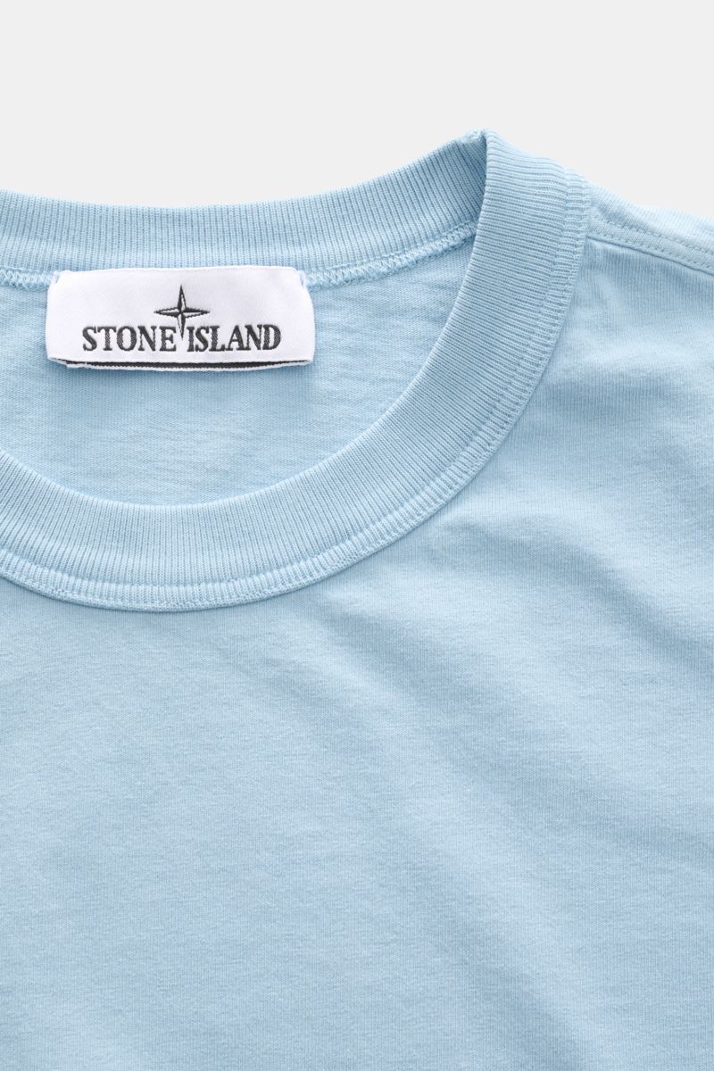 Stone Island Rundhals-T-Shirt 'Marina' hellblau shown from a close-up front perspective, highlighting the ribbed round neckline and fabric texture.  
Legeres Urlaubs-Essential: Das T-Shirt aus der STONE ISLAND 'Marina' Capsule Collection steht für läss