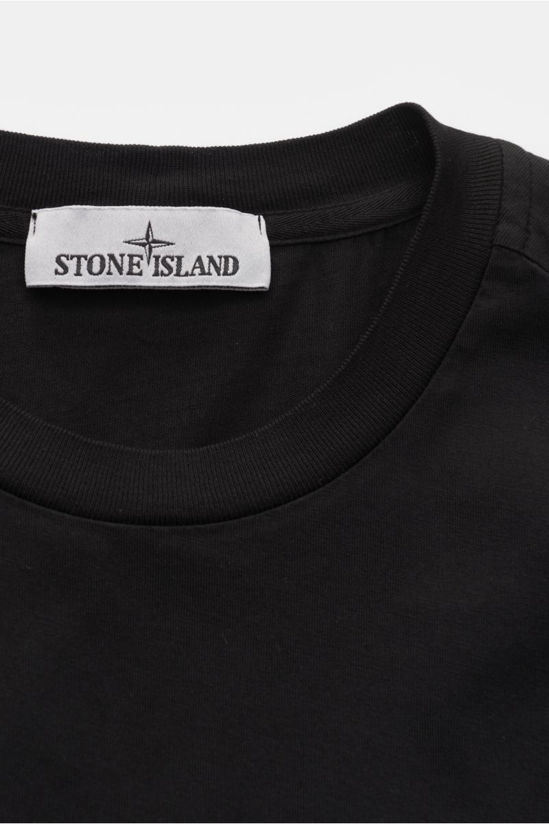 Alt-Tag (124 Zeichen): Nahaufnahme des schwarzen Stone Island T-Shirts 'Basic Cotton' mit Rundhalsausschnitt, Weblabel und weichem Baumwollstoff.