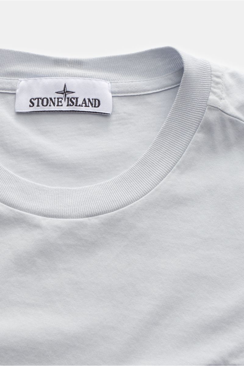 Stone Island T-Shirt 'Basic Cotton' pastellblau aus reiner Baumwolle, Slim Fit, weicher Griff, Rundhalsausschnitt, Weblabel auf Brust, Nahaufnahme von oben.