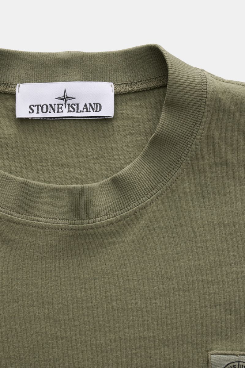 Close-up front view of Stone Island T-shirt 'Dyed Regular Fit' olive showing crew neck, woven label on chest, and soft pure cotton fabric.

A timeless basic piece: This T-shirt by STONE ISLAND in pure organic cotton effortlessly completes relaxed casua