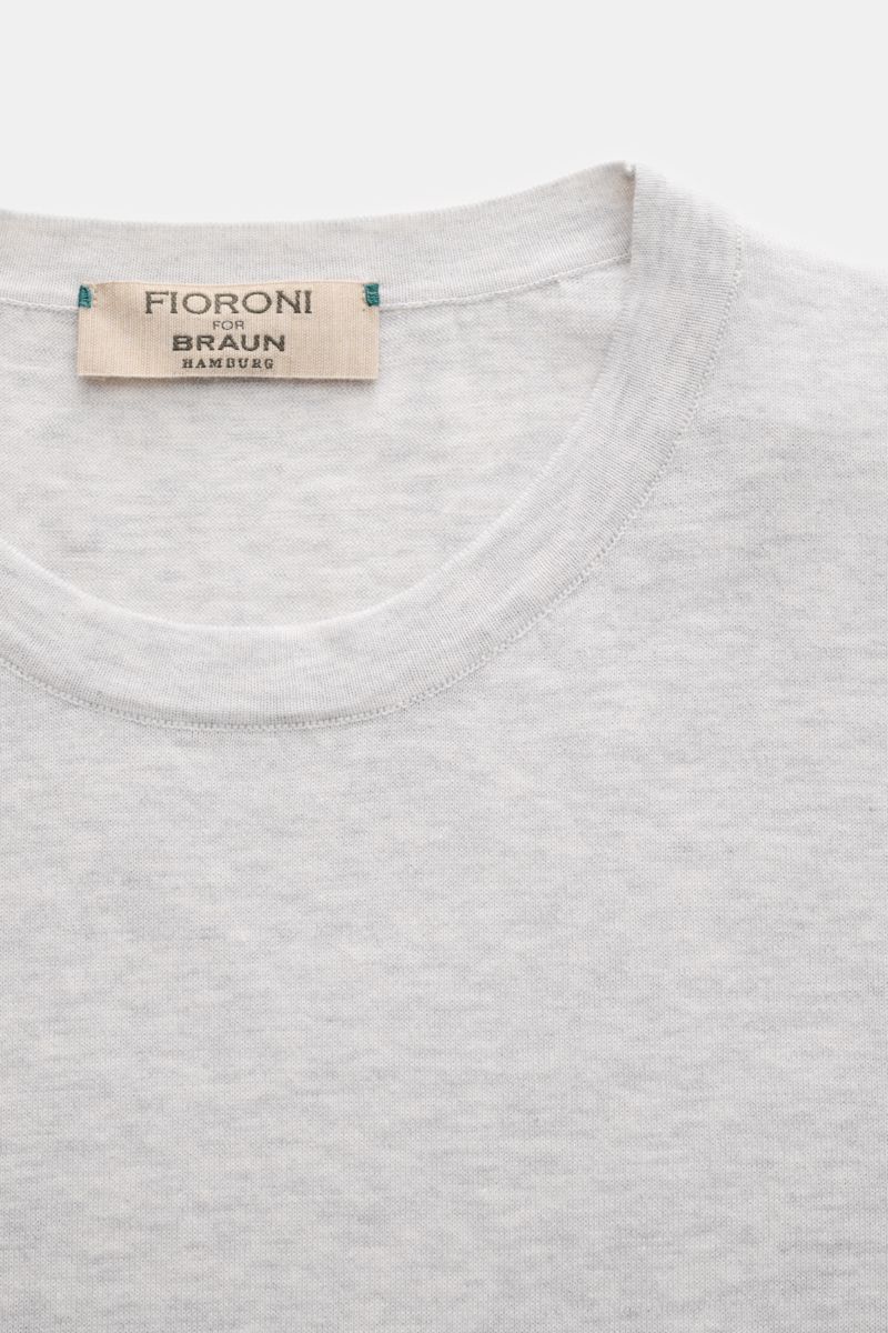Close-up front view of Fioroni Rundhals-T-Shirt hellgrau meliert showing light gray fine knit fabric with round neckline and label.

Für den gediegenen Auftritt im Frühling sorgt dieses fein gestrickte T-Shirt von FIORINI, welches aus reiner Baumwolle 
