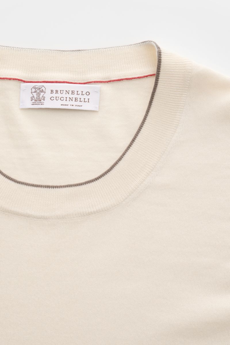 Brunello Cucinelli Kurzarmpullover creme close-up from above, showing fine knit cotton fabric, slim fit, and contrast edges at collar and sleeves. Dieser zeitlose, vielseitige Kurzarmpullover von BRUNELLO CUCINELLI aus reiner Baumwolle in feinstem Stri