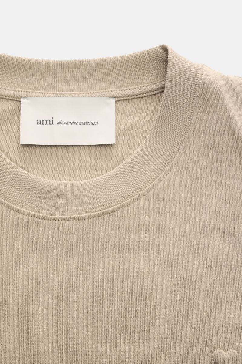 Nahaufnahme von Ami Paris Rundhals-T-Shirt taupe mit Rundhalsausschnitt, abgesteppter Herz-Logo und weichem Baumwoll-Jersey.