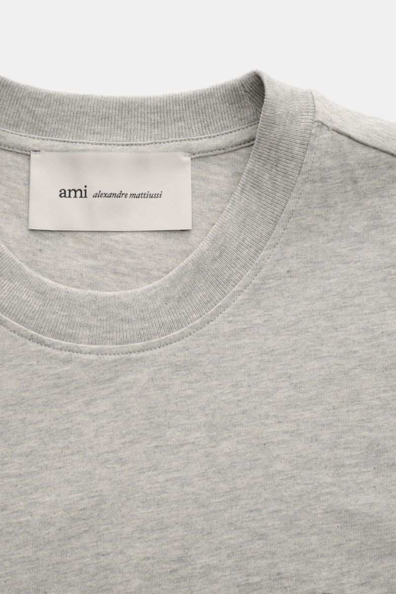 Close-up front view of Ami Paris Rundhals-T-Shirt grau meliert showing classic round neckline, soft grey melange cotton jersey, and label.

Description: Klassisches Jersey-Basic vom französischen Label AMI PARIS: Dieses T-Shirt mit Rundhalsausschnitt i